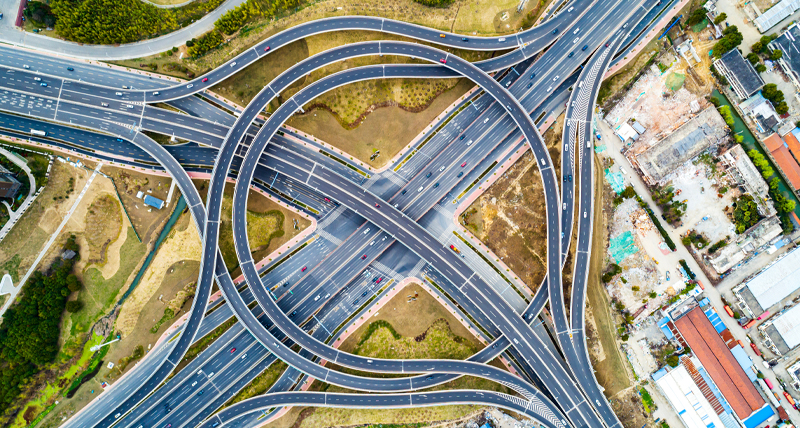 Top-down view of a large multi-level highway interchange with looping roads and merging lanes, representing the Pegasus TRK300’s efficiency in measuring mid-scale road and urban infrastructure for planning and maintenance.